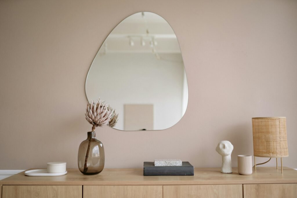 pexels-photo-5793642-5793642 Stylish minimalist interior featuring a mirror, decorative vase, and lamp.